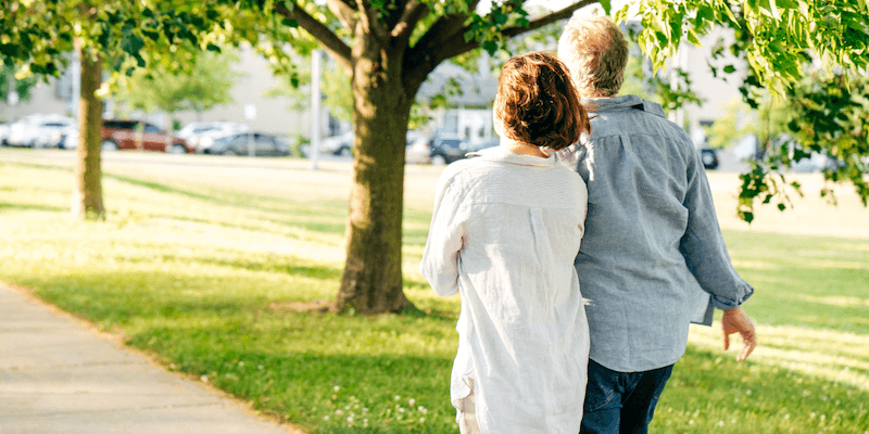 Couple holding hands walking in park